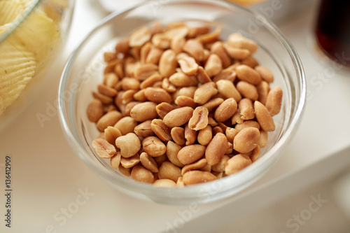 close up of roasted peanuts in glass bowl on table