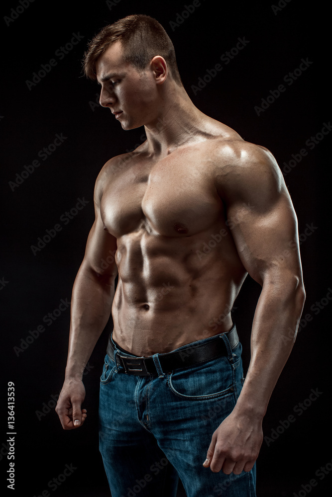 Young bodybuilder man on black background