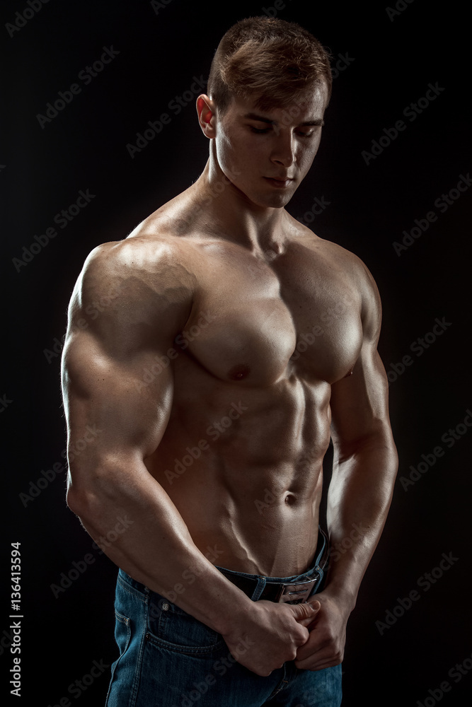 Fototapeta premium Young bodybuilder man on black background