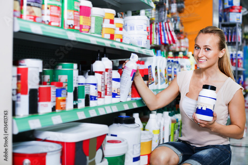 Wallpaper Mural Glad woman customer looking for paint solvent in bottle Torontodigital.ca