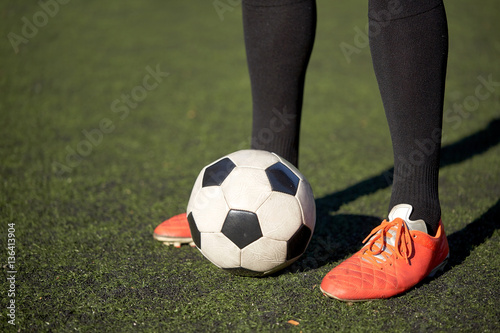soccer player playing with ball on football field © Syda Productions