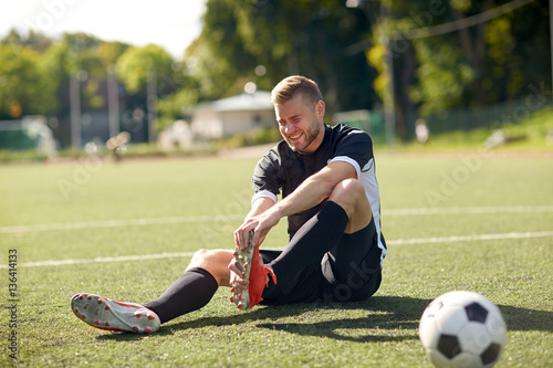 injured soccer player with ball on football field © Syda Productions