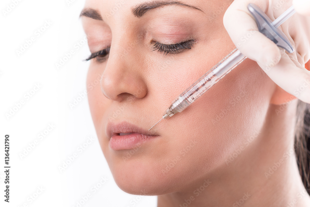 Closeup of beautiful woman receiving hyaluronic acid treatment. Isolated over white background.