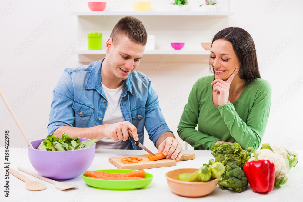Young couple cooking in their kitchen. Young couple cooking in their kitchen.