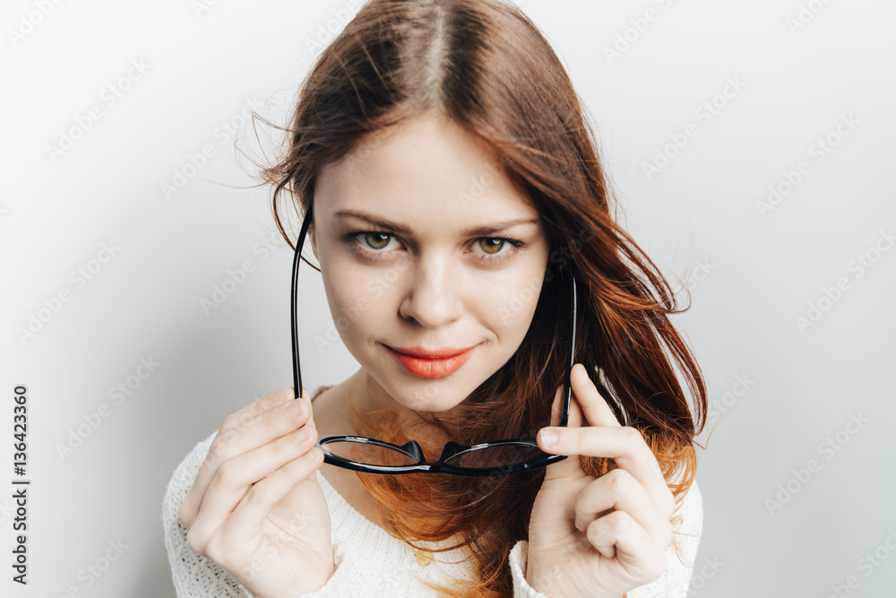 attractive woman looks at the camera and glasses in hands attractive woman looks at the camera and glasses in hands