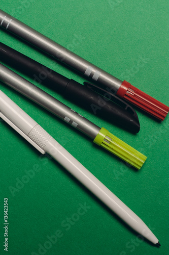 colored pens on a green background