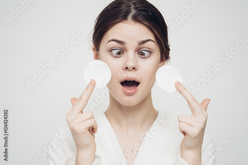 puzzled woman looks at two cottonwool discs