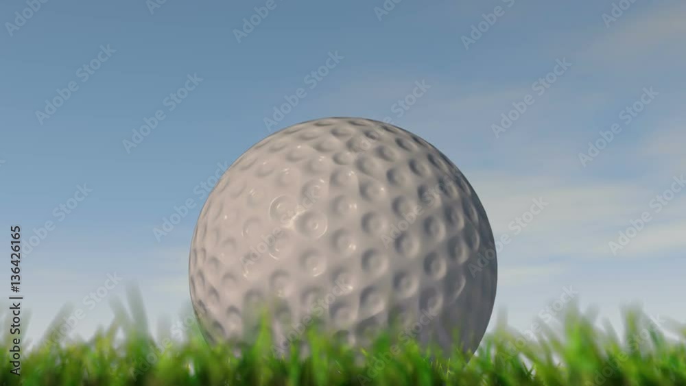 A static shallow depth of focus time lapse over a day of a golf ball in the grass on a cloudy blue sky background - 3D render A static shallow depth of focus time lapse over a day of a golf ball in the grass on a cloudy blue sky background - 3D render
