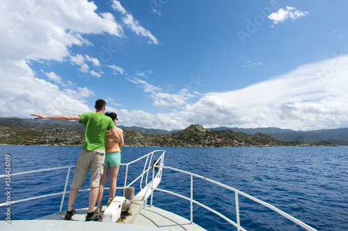 Couple man and woman on the bow of white yachts