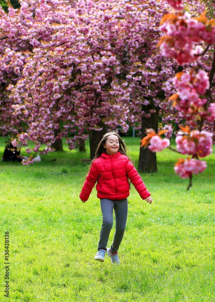 Happy beautiful girl in blossom park