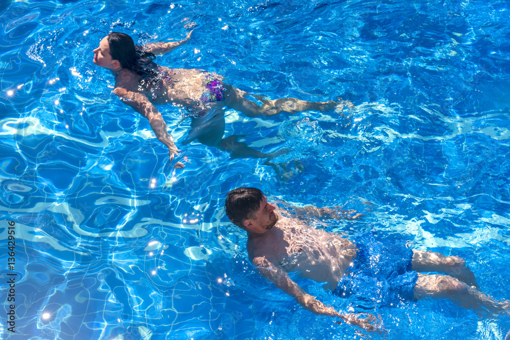 Couple man and woman swimming in the pool