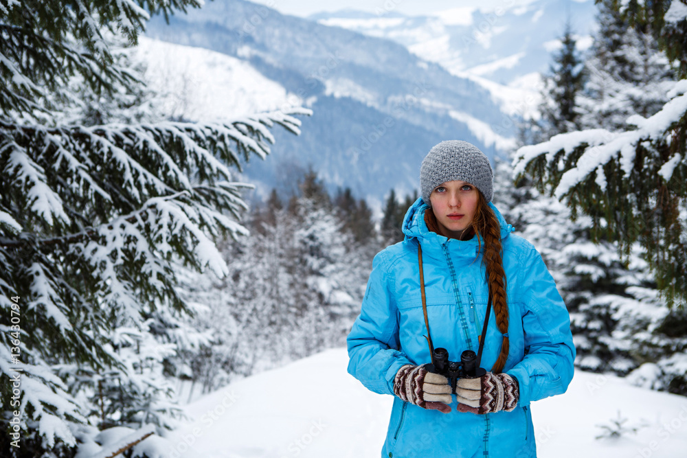 Portrait of girl with binoculars in hand on the background of winter mountains Portrait of girl with binoculars in hand on the background of winter mountains