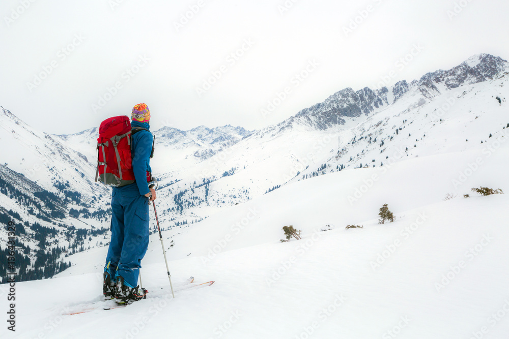 Man standing at top of ridge. Ski touring in mountains. Adventure winter extreme sport. kyrgyzstan. Tian-Shan
