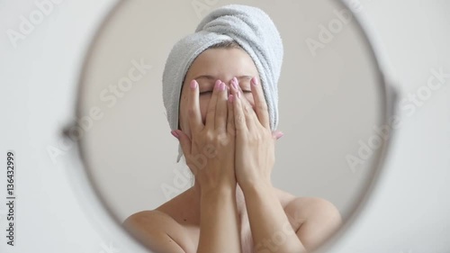 Blonde woman applying face cream on skin slow-mo 1920X1080 HD footage - Caucasian female in front of make-up mirror slow motion 1080p FullHD video