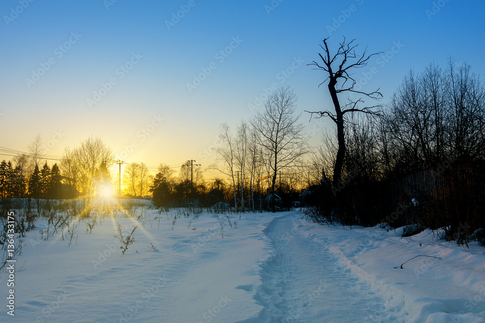 Road in moscow region, Russia. Sunset at winter in village