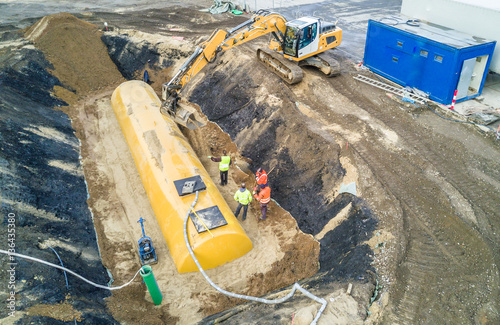 Worker installing a huge fuel tank