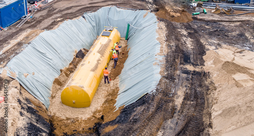 Worker installing a huge fuel tank photo