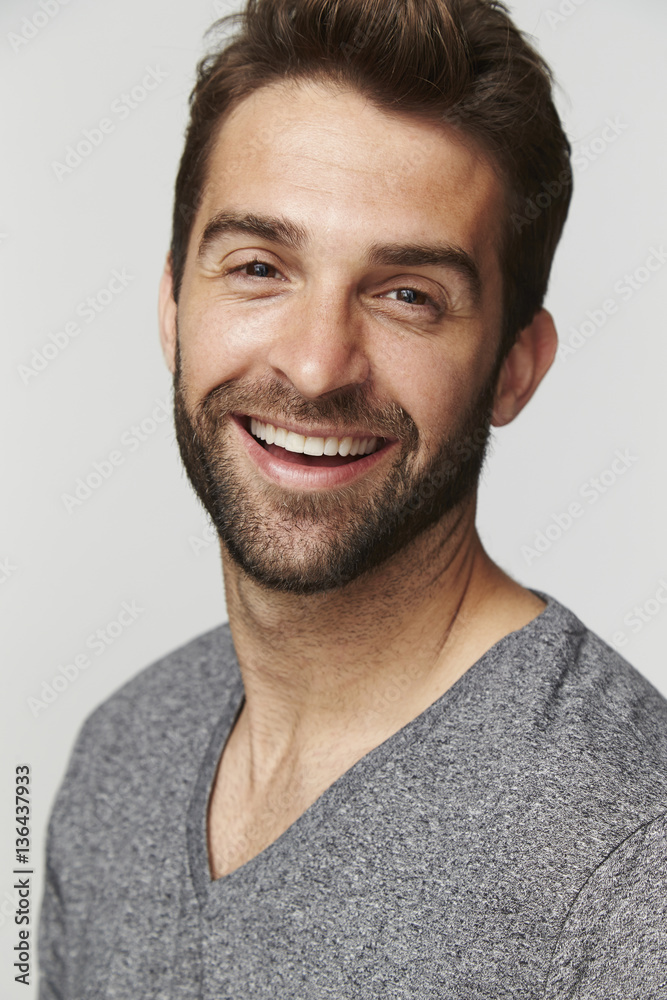 Fototapeta premium Laughing man in grey top, portrait