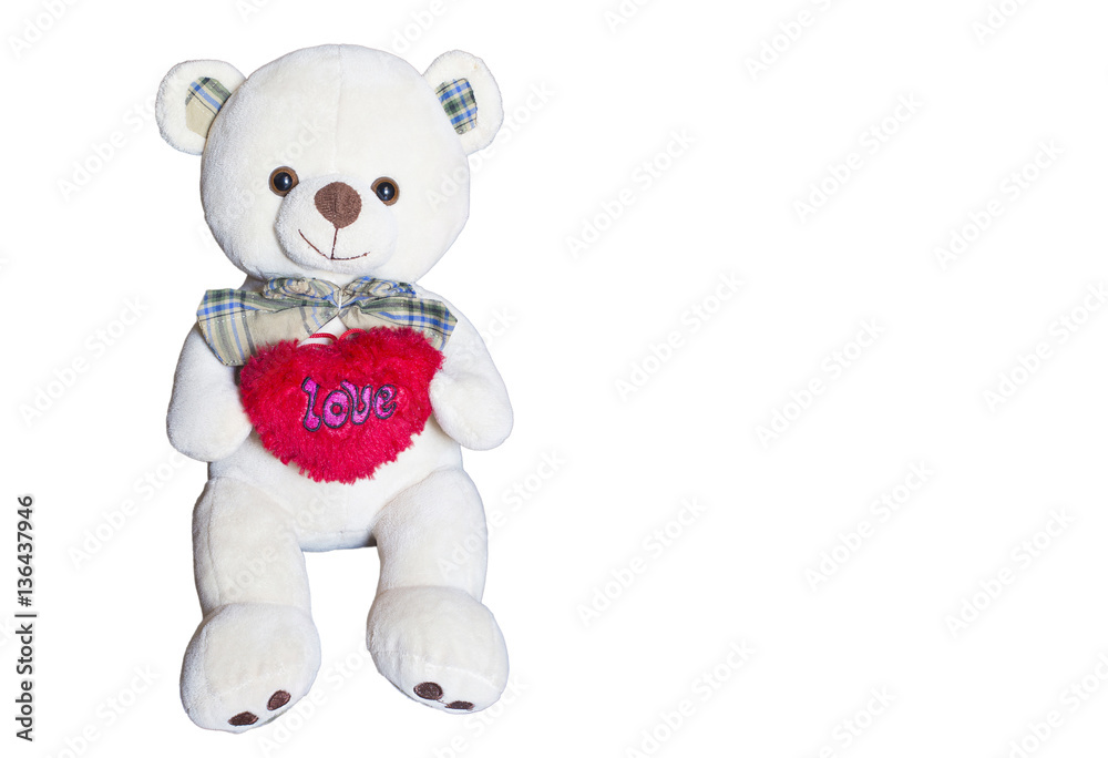 Brown bear doll is holding the red heart over the white background Brown bear doll is holding the red heart over the white background