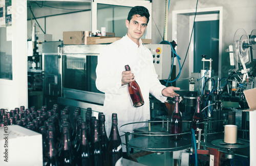 attractive man employee standing in final section of wine produc