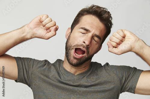 Guy yawning and stretching, studio photo