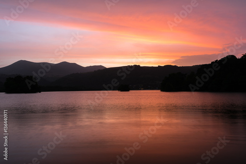 Coucher de soleil en Auvergne autour du Lac Chambon. Nuages et reflets oranges, roses © Michel