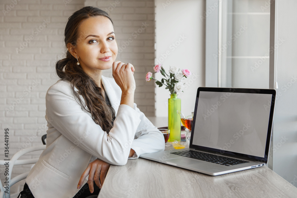 Beautiful girl leans her elbows on table with laptop Beautiful girl leans her elbows on table with laptop
