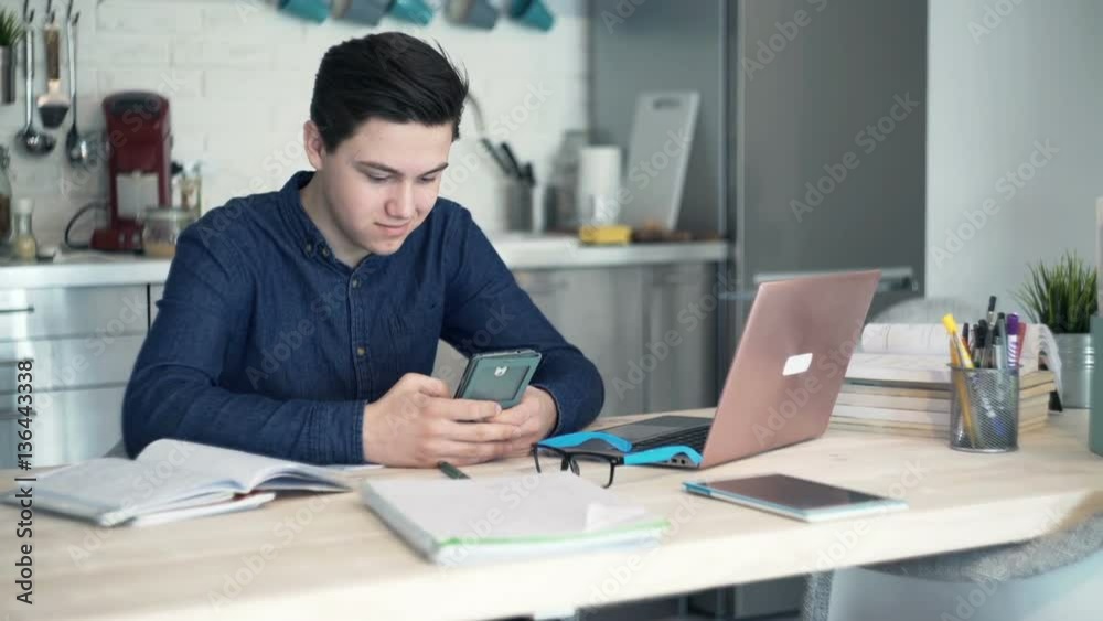 Teenager texting on smartphone in kitchen at home
Teenager texting on smartphone in kitchen at home