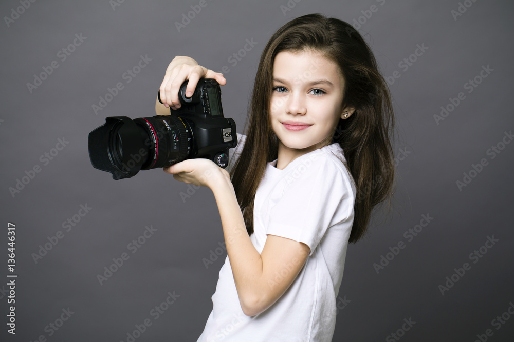 Cute brunette little girl holding an photo camera Cute brunette little girl holding an photo camera