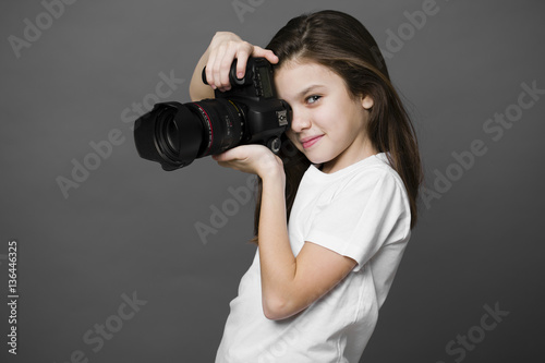 Cute brunette little girl holding an photo camera