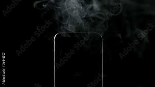 SLOW MOTION: Smoke goes out from smartphone on a black background