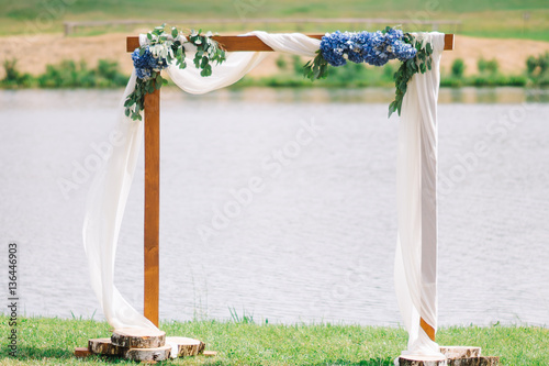 Wedding arch with flowers at the river bank photo
