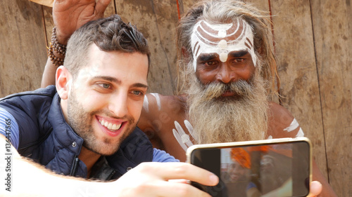 Canvas Print Tourist taking a selfie with Sadhu - Holy Man, in Varanasi, India
