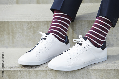 Stripy socks and white sneaker on guy, close up