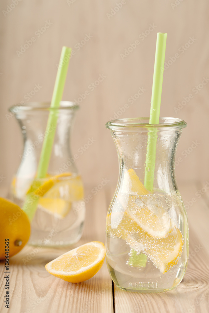 Lemonade drink of soda water, lemon and mint leaves in jar on a rustic wooden background