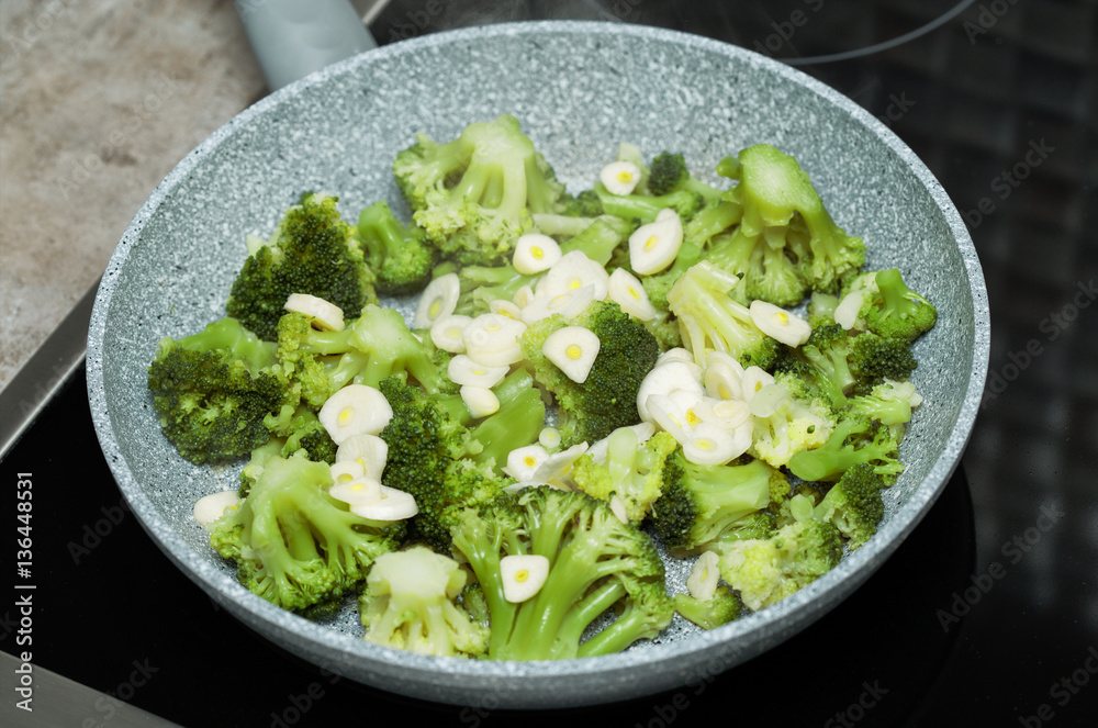 fresh broccoli with garlic in a frying pan fresh broccoli with garlic in a frying pan
