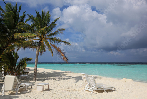Fototapeta Naklejka Na Ścianę i Meble -  Plastic sunbeds and table on the tropical beach, Maldives
