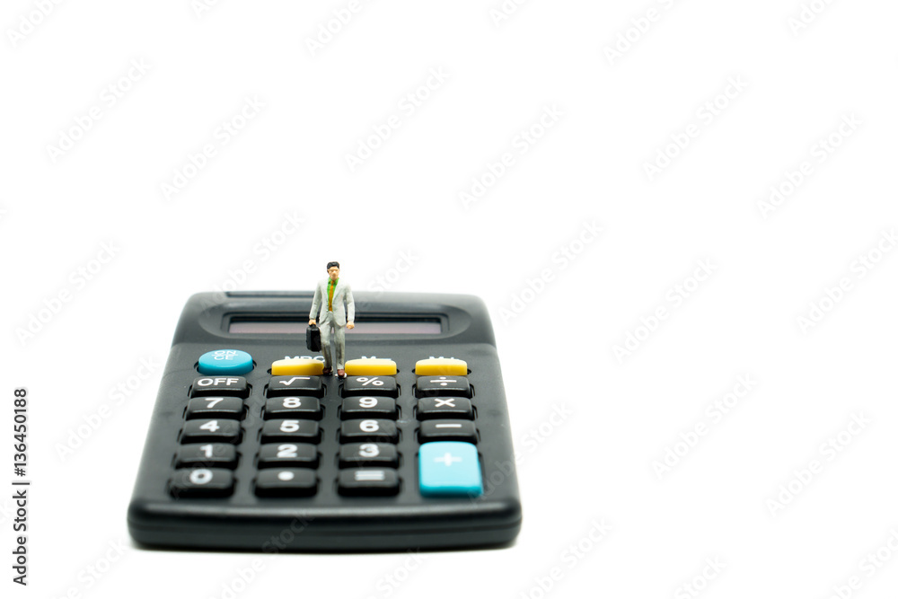 Miniature people businessman on calculator Miniature people businessman on calculator