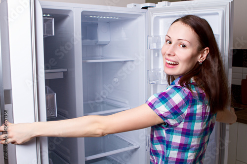 female teenager looking in empty refrigerator