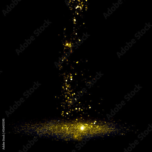 Golden glitter flakes falling, isolated on black background