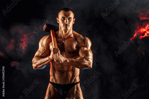 Fotografie Portrait of serious muscular topless man with sledgehammer