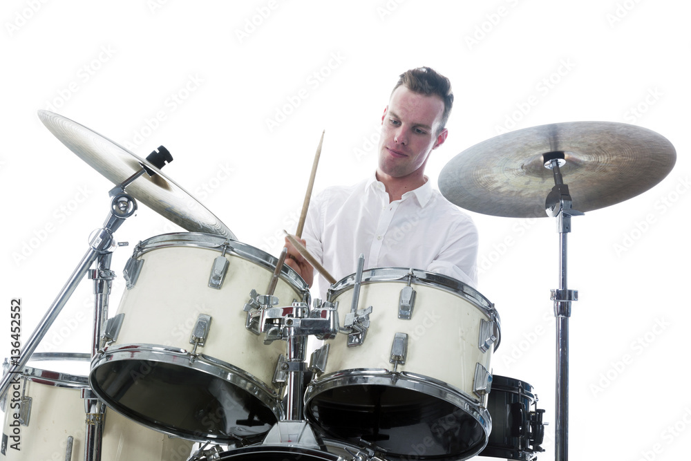Obraz premium drummer behind drum set wears white shirt and plays the drums