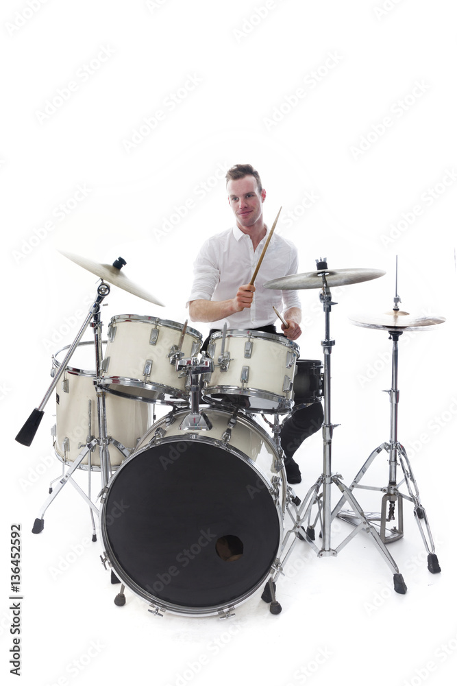 Fototapeta premium drummer behind drum set wears white shirt and plays the drums