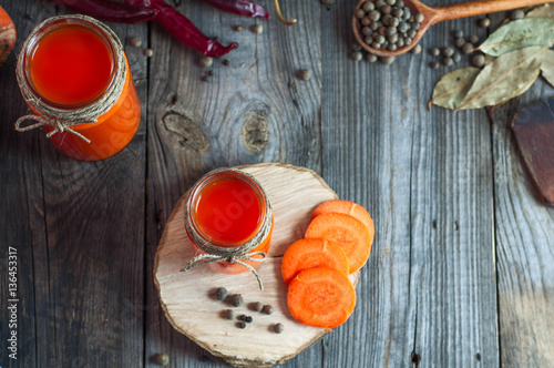 Fresh carrot juice in glass jars, top view