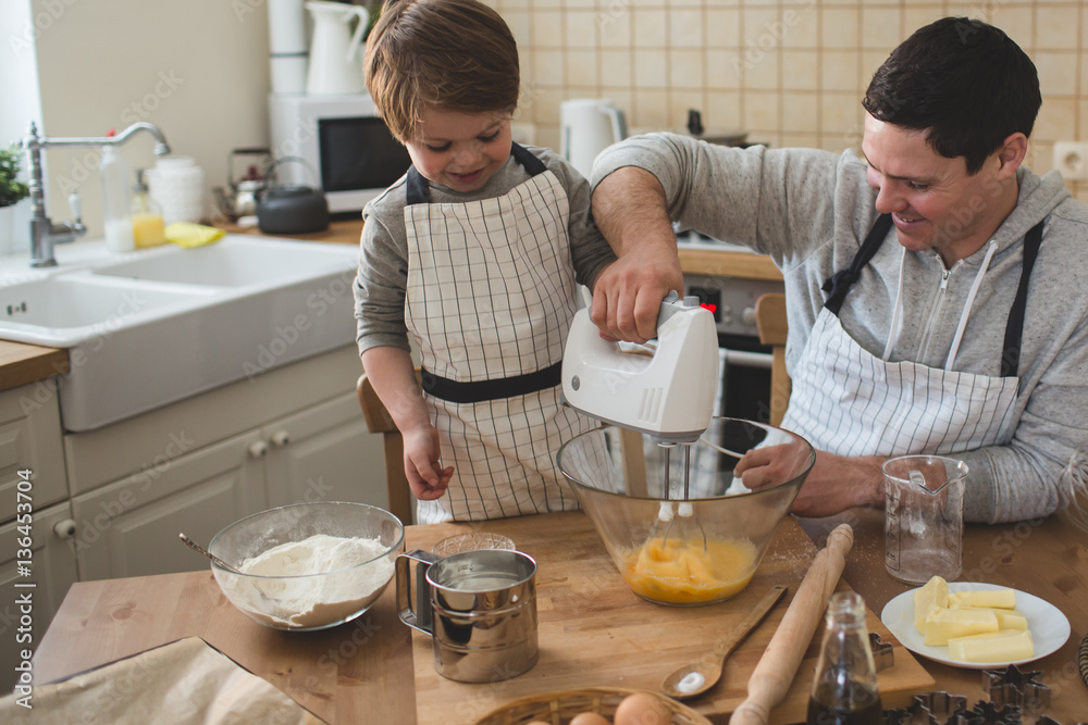 A father and his son cooking - obrazy, fototapety, plakaty 