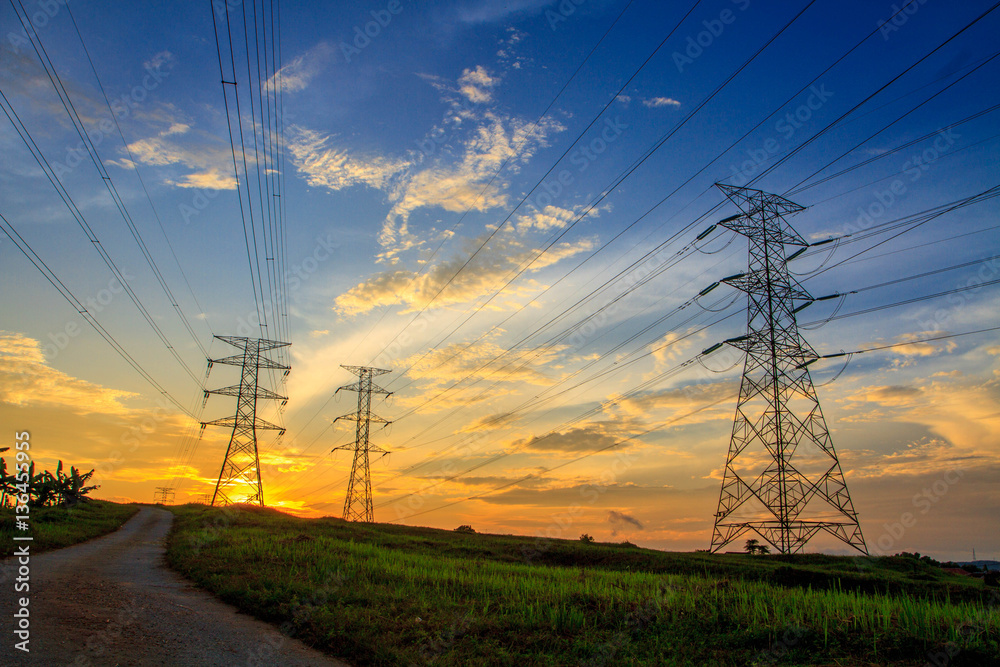 A high voltage of transmission tower in the morning sunrise with the beauty of a blue sky
