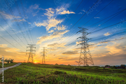 A high voltage of transmission tower in the morning sunrise with the beauty of a blue sky