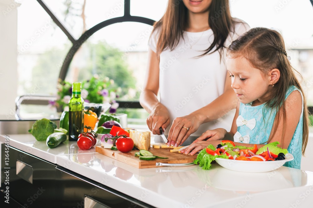 Cute little girl cooking with her mother, healthy food Cute little girl cooking with her mother, healthy food