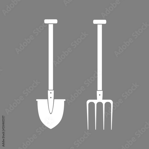 White spade and pitchfork on grey background