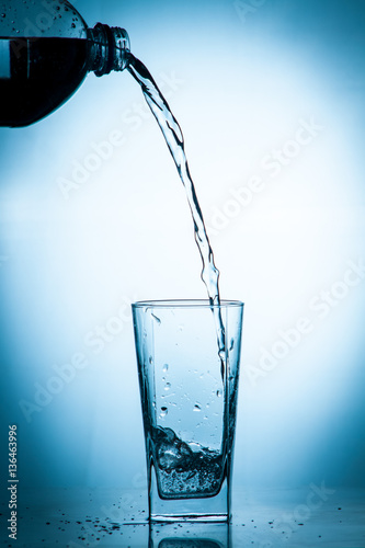 Glass glass of water on the isolated background. Mountain mineral pure mountain water with gas bubbles and a spray tonic refreshing sports drink.